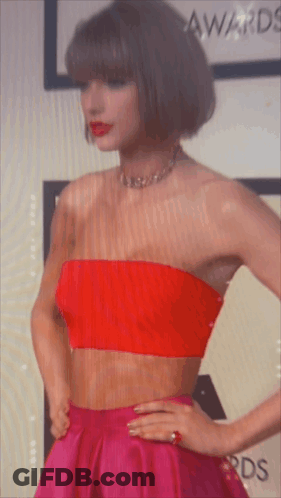A Woman Wearing A Red Strapless Top And A Pink Skirt GIF