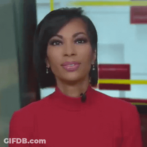 A Woman Wearing A Red Sweater And Earrings Is Standing In Front Of A Microphone . GIF