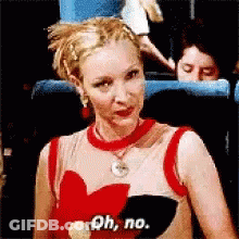 A Woman Wearing A Red Top With A Heart On It Says Oh No GIF