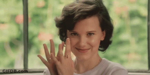A Woman Wearing A Ring On Her Finger Is Smiling And Looking At The Camera GIF