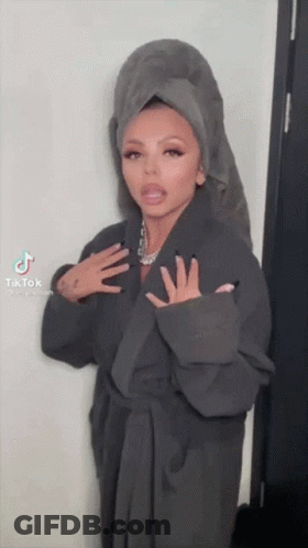 A Woman Wearing A Robe And A Towel On Her Head . GIF