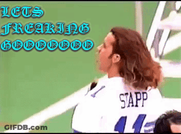 A Woman Wearing A Sapp Jersey Stands In Front Of A Green Wall GIF