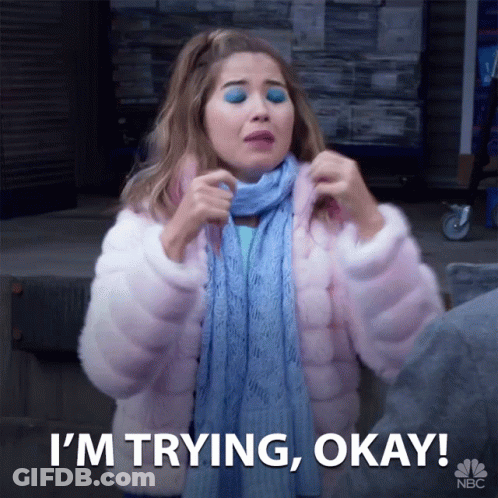 A Woman Wearing A Scarf And A Pink Coat Says I 'M Trying Okay GIF