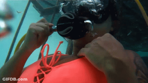 A Woman Wearing A Scubapro Mask Is Swimming In The Water GIF