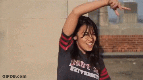A Woman Wearing A Shirt That Says Boston University Is Smiling GIF