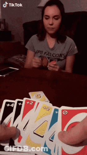A Woman Wearing A Shirt That Says Falcons Is Playing Uno GIF