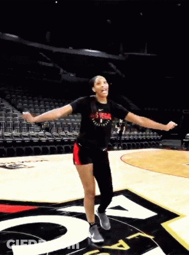 A Woman Wearing A Shirt That Says Las Vegas On It Is Dancing On A Basketball Court GIF