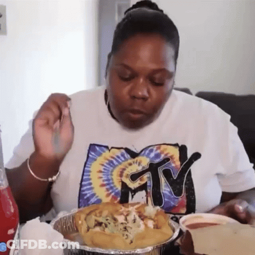 A Woman Wearing A Shirt That Says Mtv Is Eating Food GIF