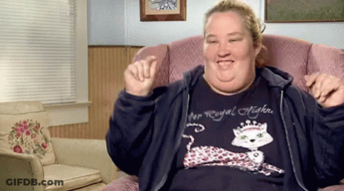 A Woman Wearing A Shirt That Says Royal Highness Is Sitting In A Chair GIF