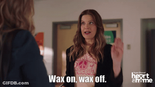A Woman Wearing A Shirt That Says " Wax On Wax Off " Is Talking To Another Woman GIF