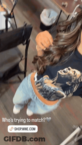 A Woman Wearing A Shirt That Says ' Who 'S Trying To Match ? Shop.wwe.com ' On It GIF