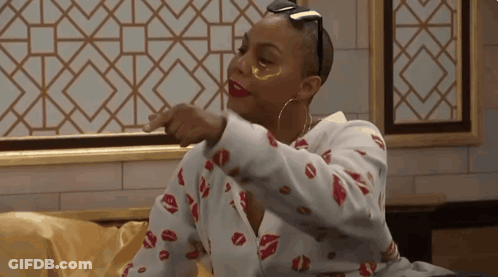 A Woman Wearing A Shirt With Kisses On It Is Pointing At Something GIF