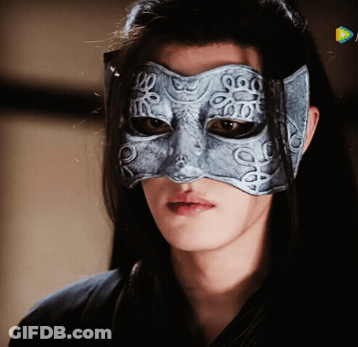 A Woman Wearing A Silver Mask With A Pattern Of Circles On It GIF
