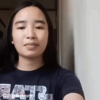 A Woman Wearing A Star Wars Shirt Is Taking A Selfie With Her Phone . GIF