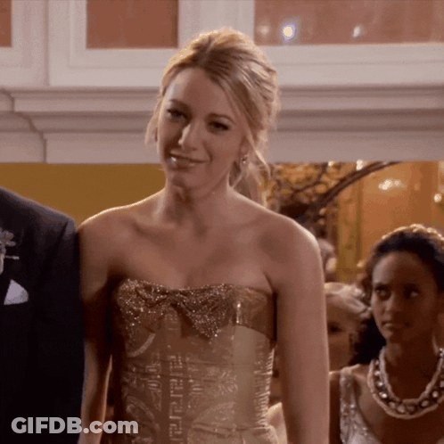 A Woman Wearing A Strapless Gold Dress With A Bow GIF