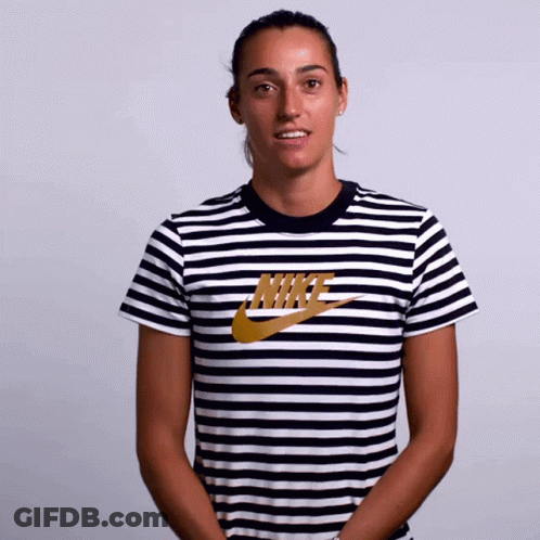 A Woman Wearing A Striped Nike Shirt Smiles GIF
