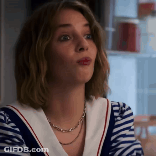 A Woman Wearing A Striped Shirt And A Necklace Looks Surprised GIF