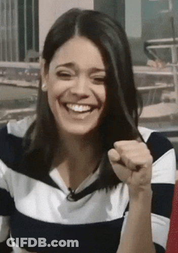 A Woman Wearing A Striped Shirt Is Laughing And Holding Her Hair GIF