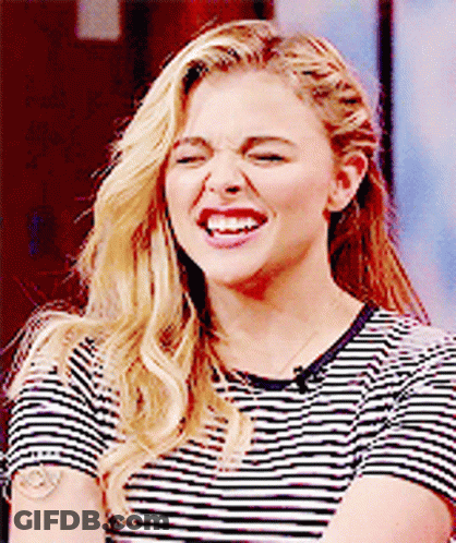 A Woman Wearing A Striped Shirt Is Making A Funny Face . GIF