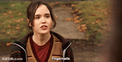 A Woman Wearing A Sweater And A Red Shirt Is Talking About Fingernails GIF