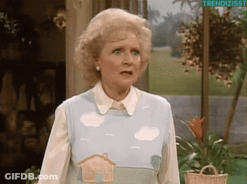 A Woman Wearing A Sweater With A House And Clouds On It GIF