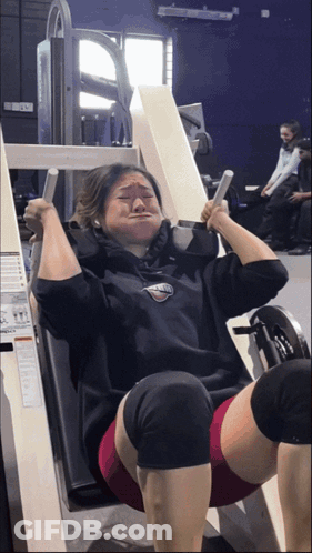 A Woman Wearing A Sweatshirt That Says ' Athletic ' On It Is Using A Machine GIF