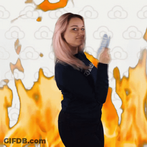 A Woman Wearing A Sweatshirt That Says ' Daddy ' On It Stands In Front Of Flames GIF