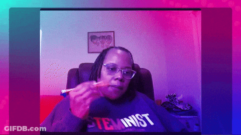A Woman Wearing A Sweatshirt That Says Feminist Is Eating Something GIF