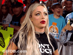 A Woman Wearing A T-Shirt That Says " Do N't Touch " Is Standing In Front Of A Crowd GIF
