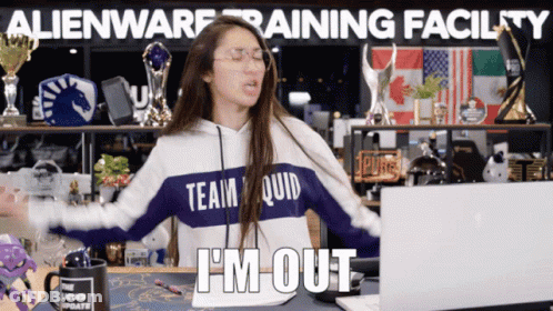 A Woman Wearing A Team Quid Sweatshirt Is Sitting In Front Of A Laptop GIF