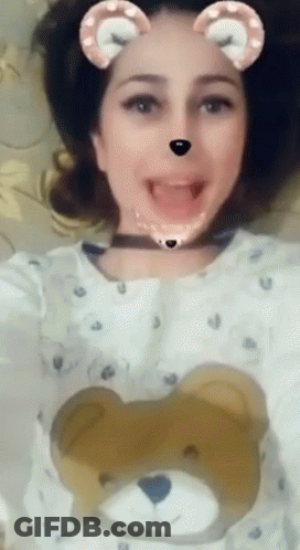 A Woman Wearing A Teddy Bear Sweater Is Making A Face GIF