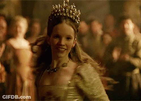 A Woman Wearing A Tiara And A Dress Is Smiling GIF