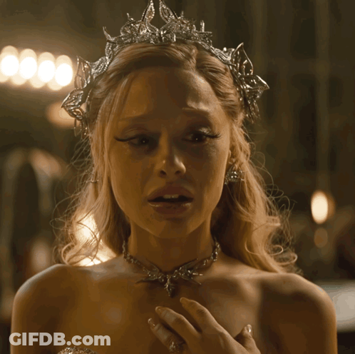A Woman Wearing A Tiara And A Necklace Has A Sad Look On Her Face GIF