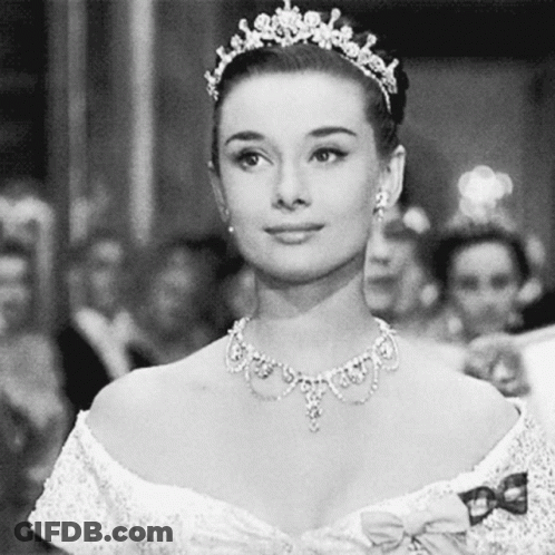 Smiling Woman Wearing Tiara And Necklace In Black And White GIF