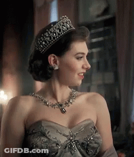 A Woman Wearing A Tiara And A Necklace Is Smiling . GIF