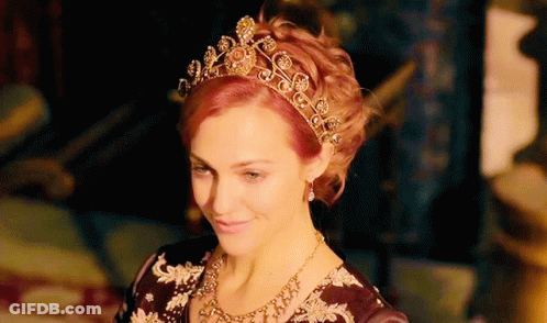 A Woman Wearing A Tiara And Necklace Is Smiling GIF