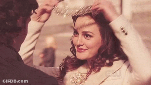 A Woman Wearing A Tiara Is Being Helped By A Man With A Cw Logo In The Corner GIF