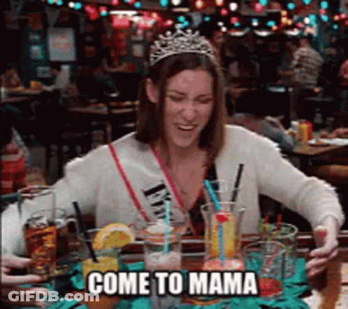 A Woman Wearing A Tiara Is Sitting At A Table With Drinks And The Words Come To Mama Below Her GIF