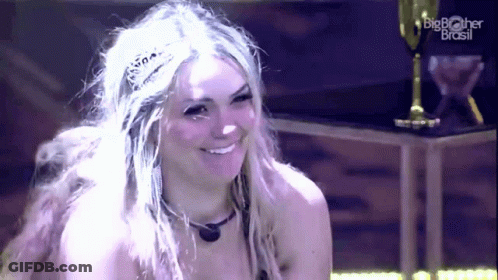 A Woman Wearing A Tiara Is Smiling In Front Of A Big Brother Brasil Logo GIF