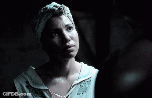 A Woman Wearing A Turban And A White Shirt Looks Up At Something GIF