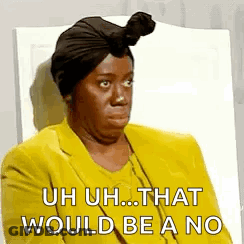 A Woman Wearing A Turban And A Yellow Jacket Is Sitting In A Chair And Making A Funny Face . GIF