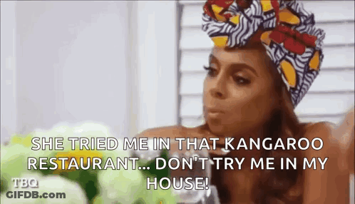 A Woman Wearing A Turban Is Sitting At A Table And Talking To Someone . GIF