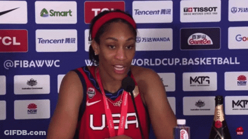 A Woman Wearing A U.s.a. Jersey Stands In Front Of A Wall Of Sponsors GIF
