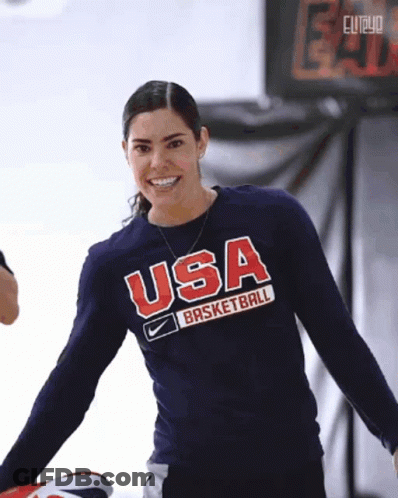 A Woman Wearing A USA Basketball Shirt Smiles For The Camera GIF
