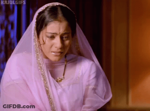 A Woman Wearing A Veil And A Necklace Is Crying And Looking Down . GIF
