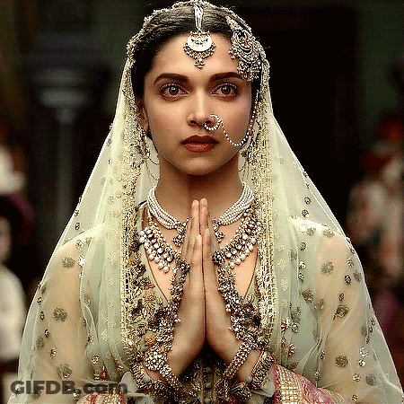 A Woman Wearing A Veil And A Nose Ring Is Praying GIF