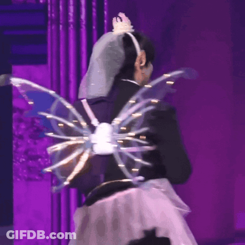 A Woman Wearing A Veil And Wings On A Stage GIF
