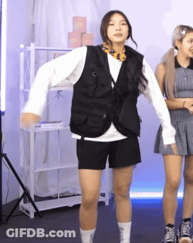 A Woman Wearing A Vest And Shorts Is Dancing In Front Of A Shelf That Says ' Socks ' On It GIF