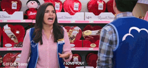 A Woman Wearing A Vest That Says I Love You Is Talking To A Man GIF