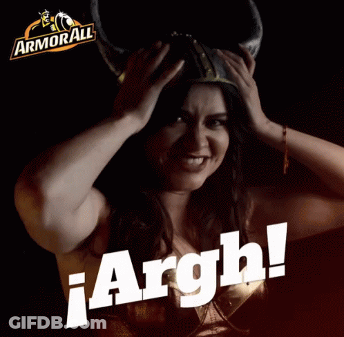 A Woman Wearing A Viking Helmet Is Holding Her Head In Front Of A Sign That Says Armorall GIF